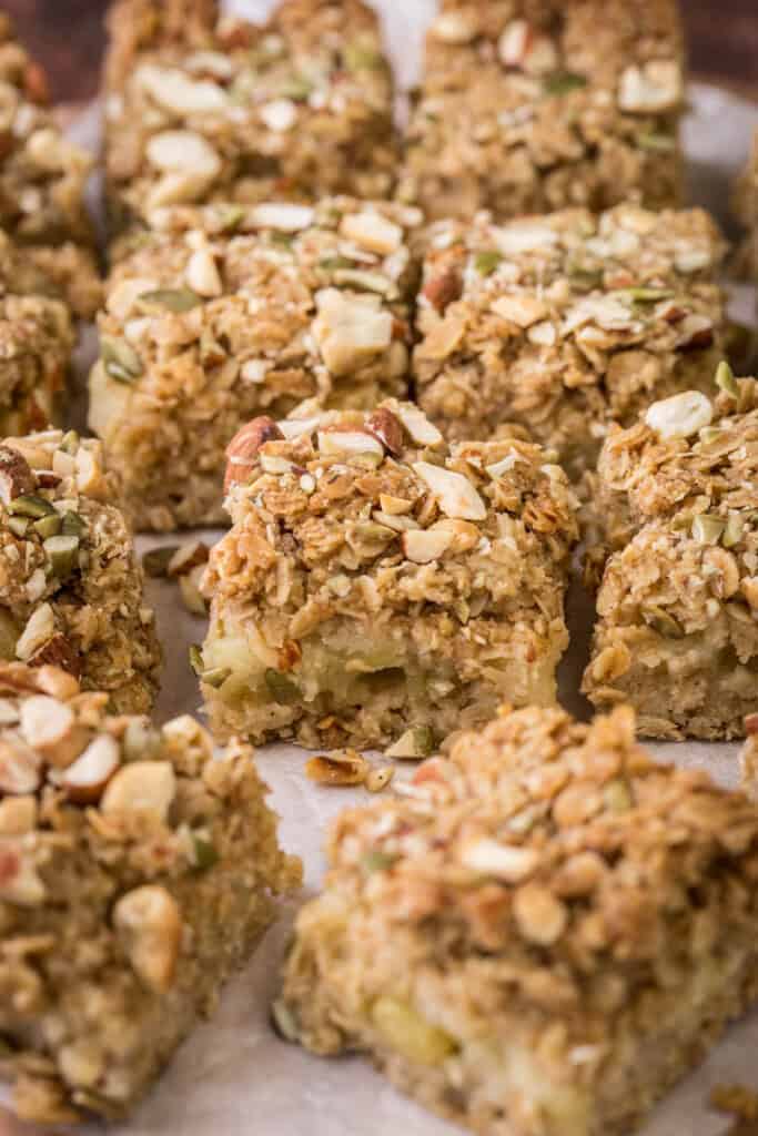 Apple flapjacks shown from the side so you can see the nutty topping, the buttery oat mixture and the fluffy bramley apple middle.