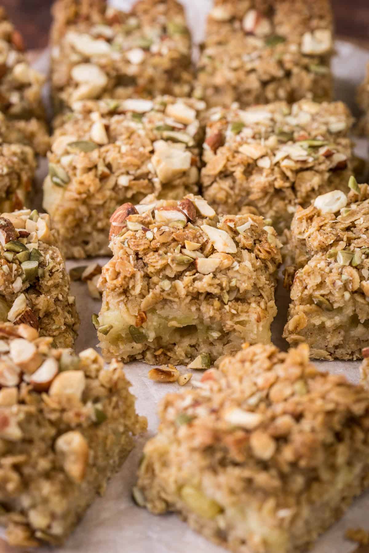 Apple flapjacks shown from the side so you can see the nutty topping, the buttery oat mixture and the fluffy bramley apple middle.