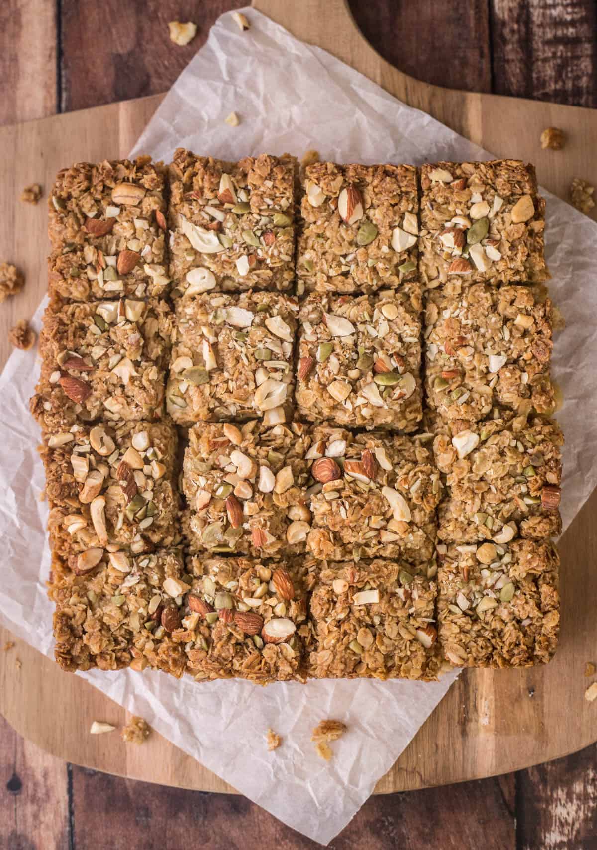 Apple Flapjacks on a wooden board cut into 16 pieces.