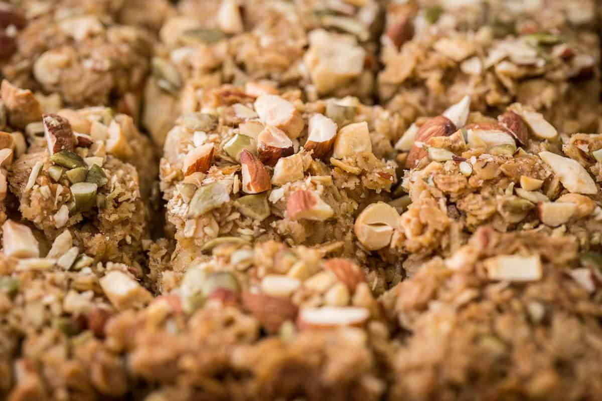 Apple flapjacks shown from the side so you can see the nutty topping, the buttery oat mixture and the fluffy bramley apple middle.