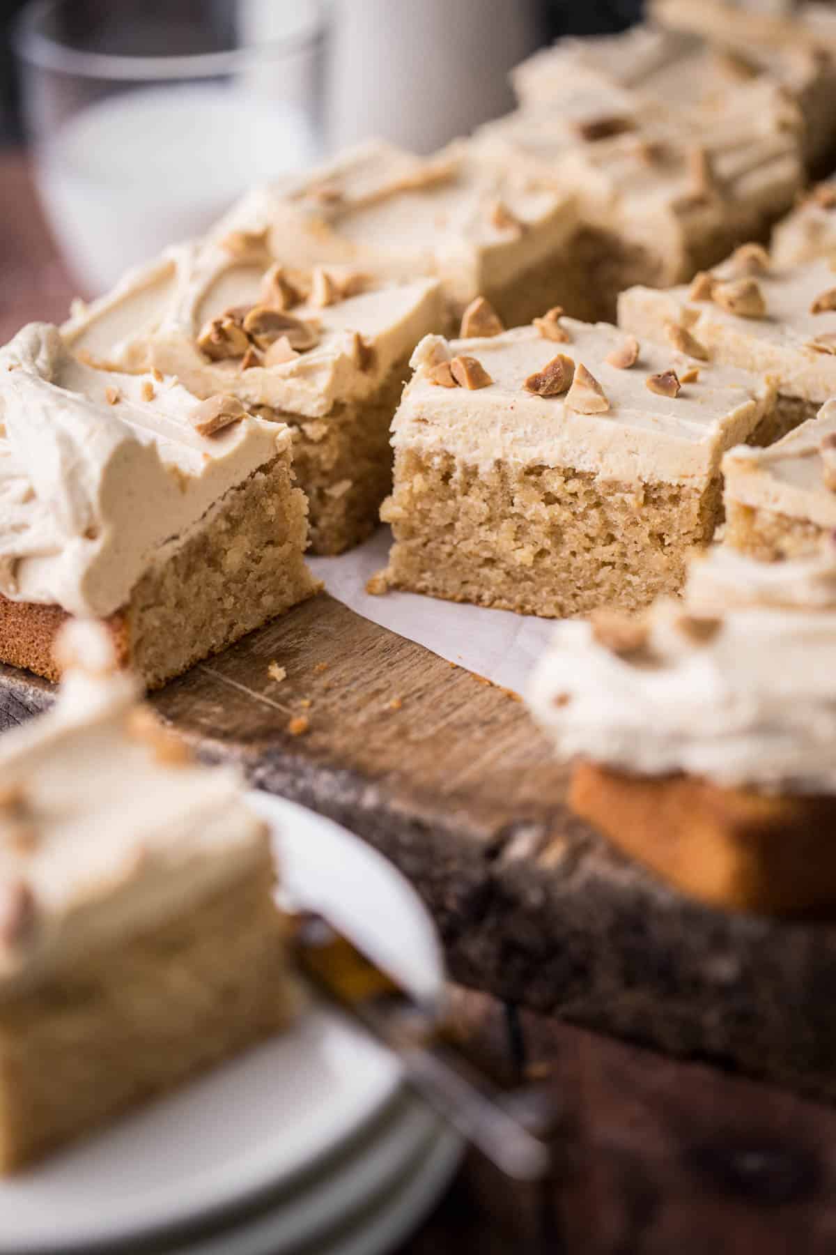 Sliced Gluten-Free Peanut Butter Cake on wooden board showing soft and fluffy sponge and creamy buttercream.