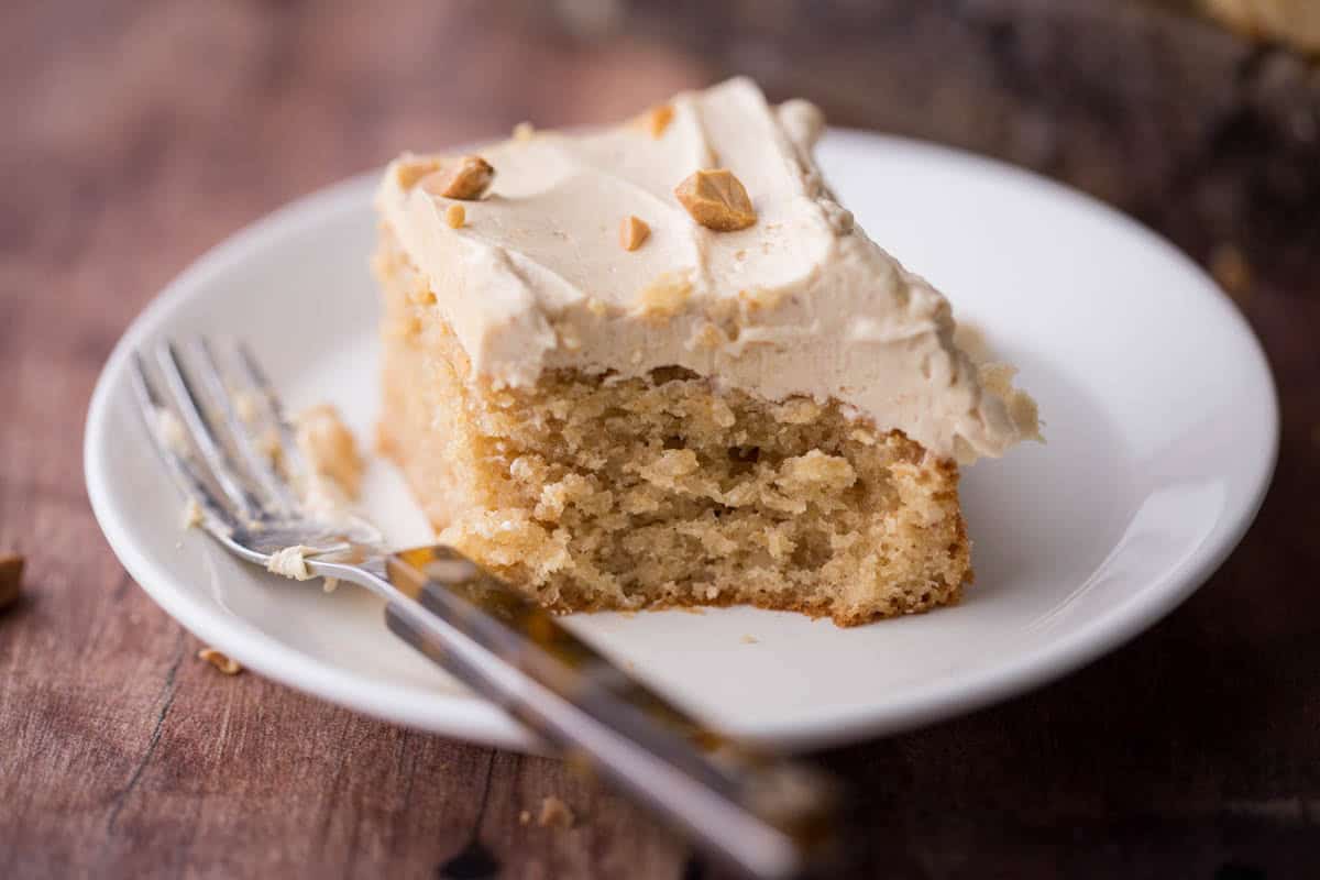 Slice of Gluten-Free Peanut Butter Cake with forkful taken out showing soft and fluffy sponge.