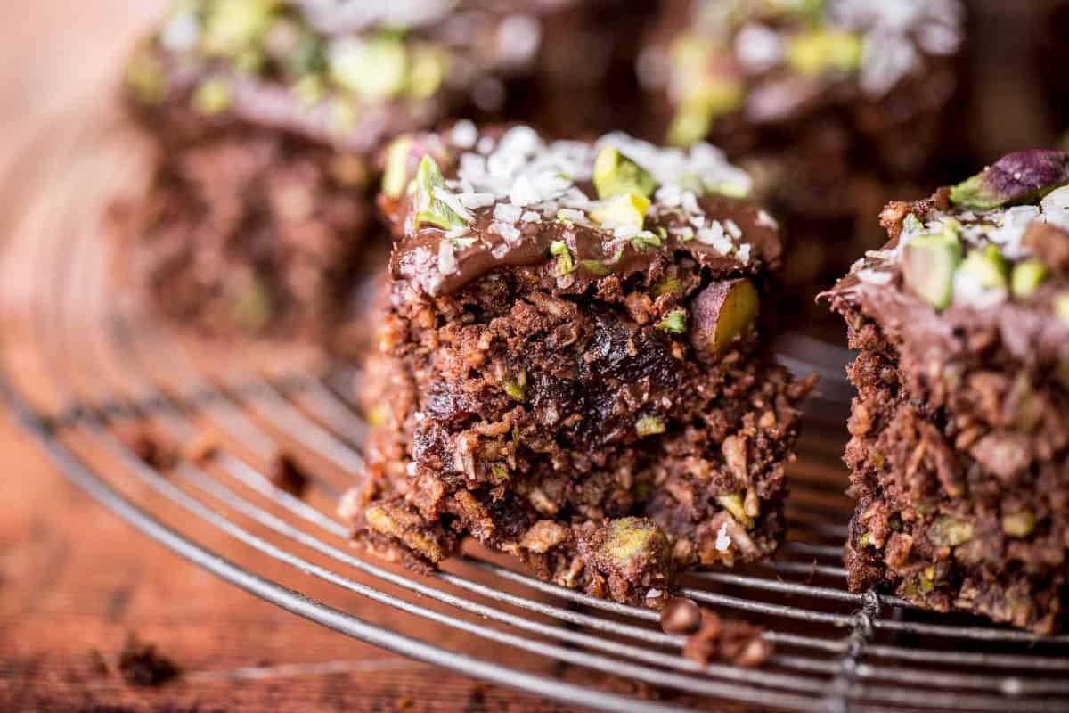 Flourless Chocolate Pistachio Coconut Slice on a wire rack.