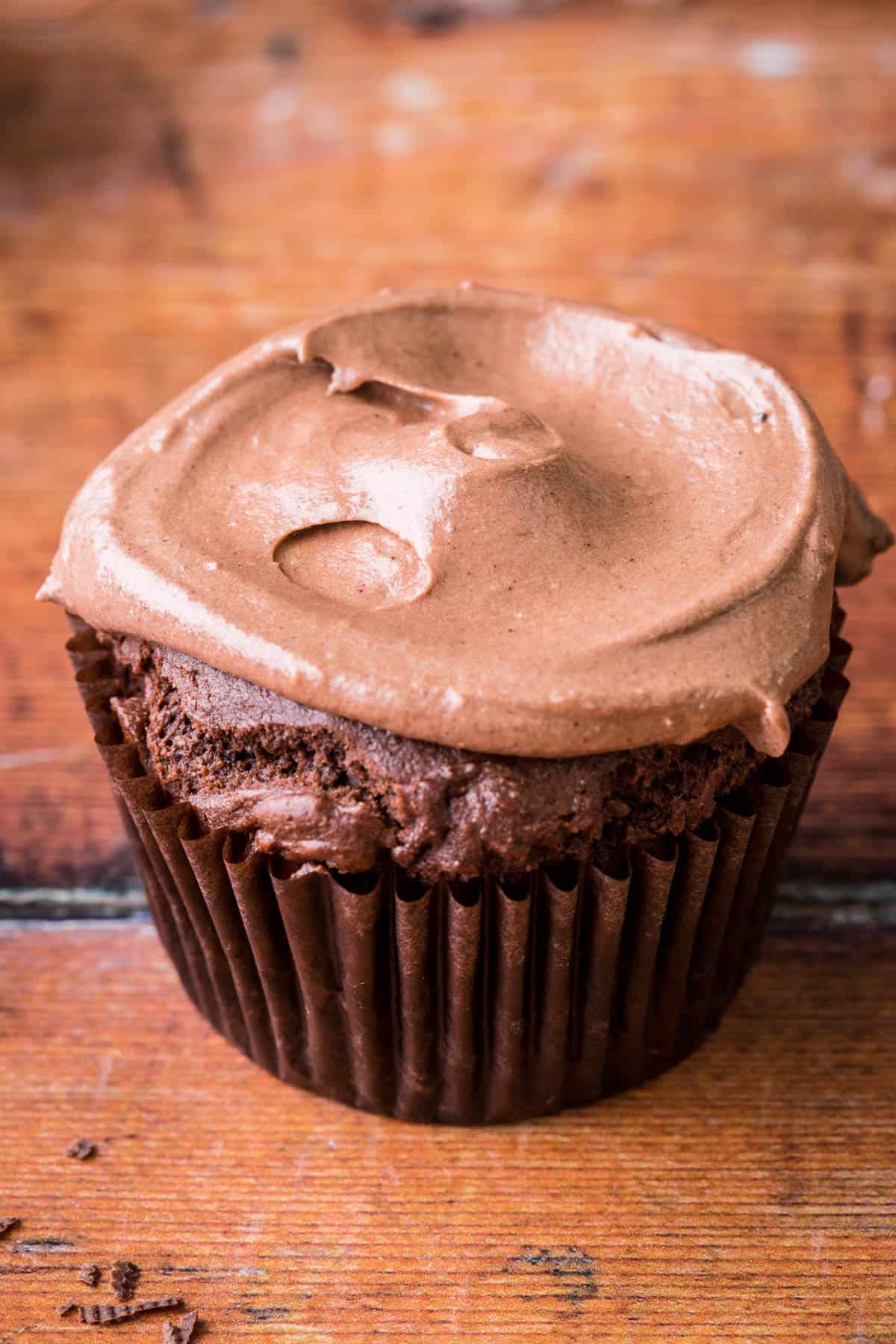Chocolate cupcake showing buttercream applied to cupcake using a teaspoon.