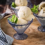Homemade Vanilla Ice Cream in a glass dish decorated with a sprig of mint.