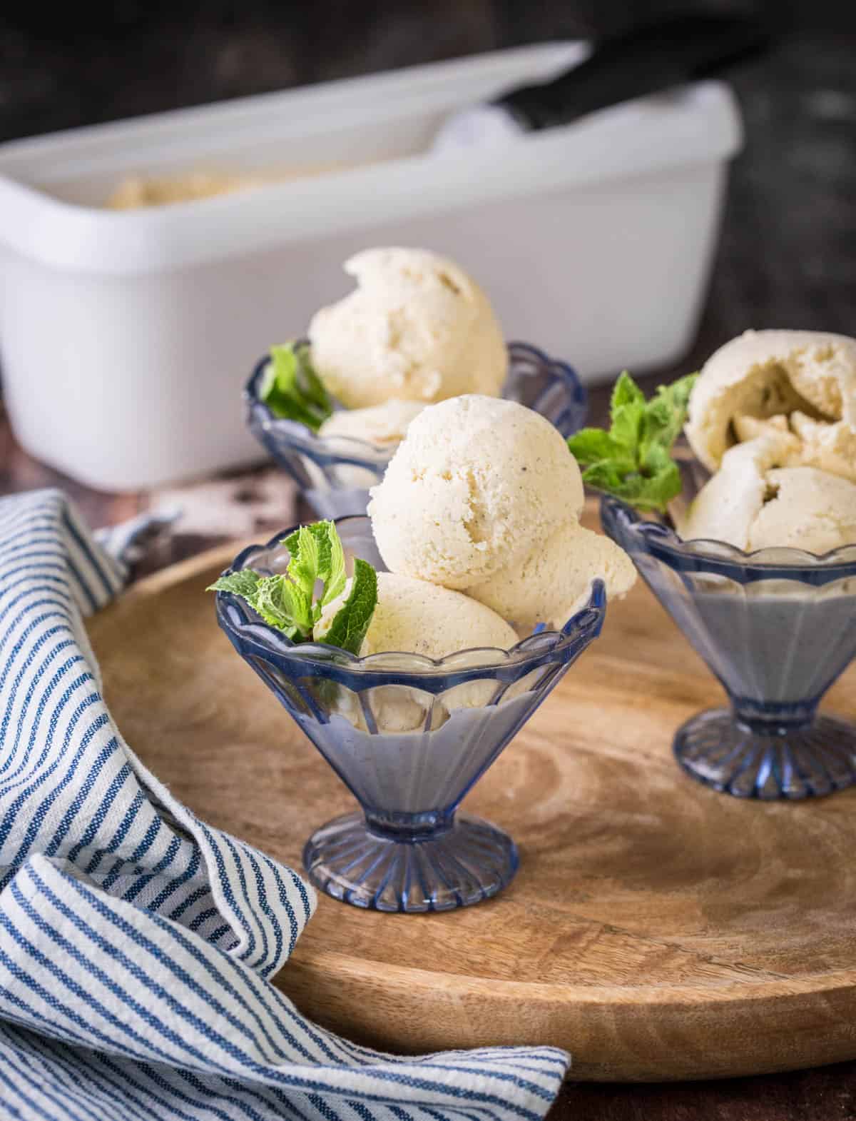 Homemade Vanilla Ice Cream in glass dishes decorated with a sprig of mint.