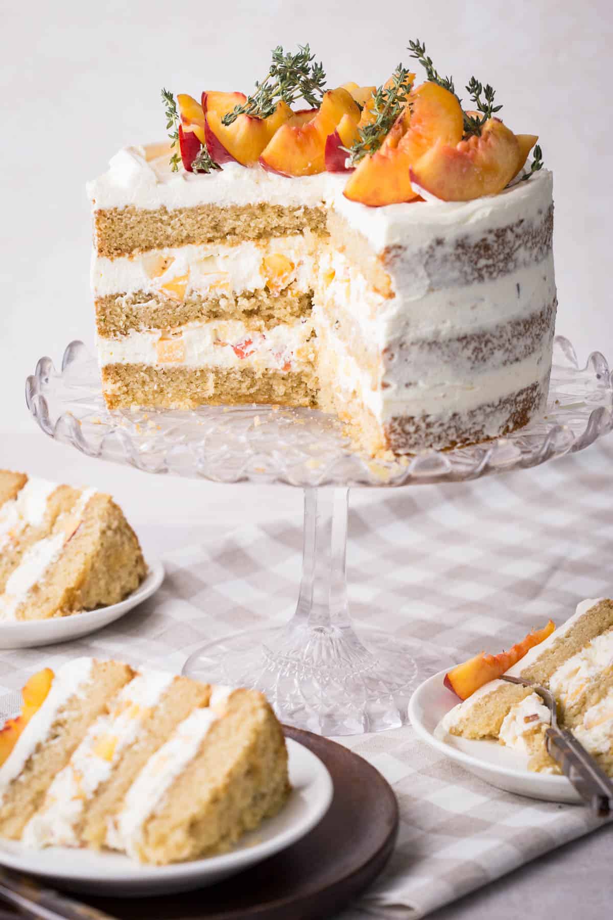 Nectarine Thyme Limoncello Cake cut into showing soft and fluffy sponge and light creamy filling stuffed with nectarines.