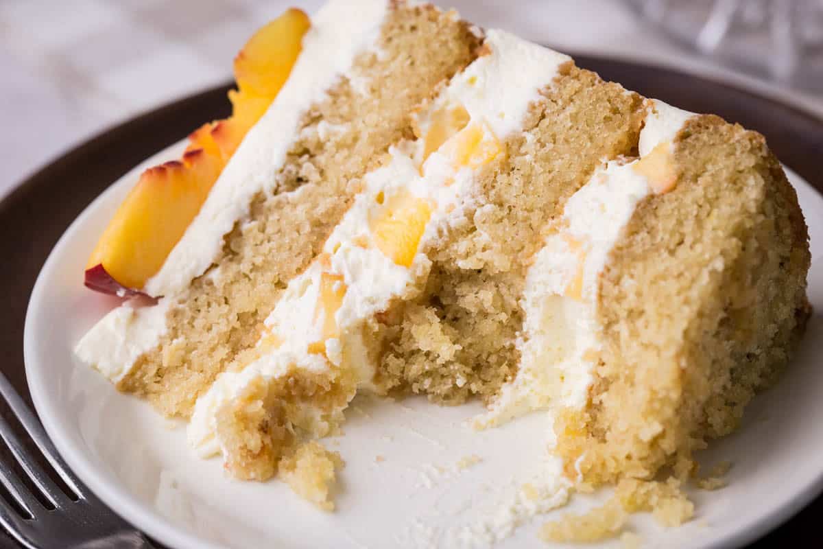 Slice of Nectarine Thyme Limoncello Cake on a plate with a forkful taken out.
