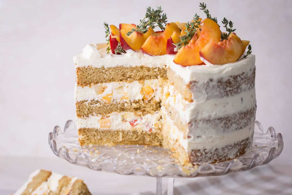 Nectarine Thyme Limoncello Cake cut into showing soft and fluffy sponge and light creamy filling stuffed with nectarines.