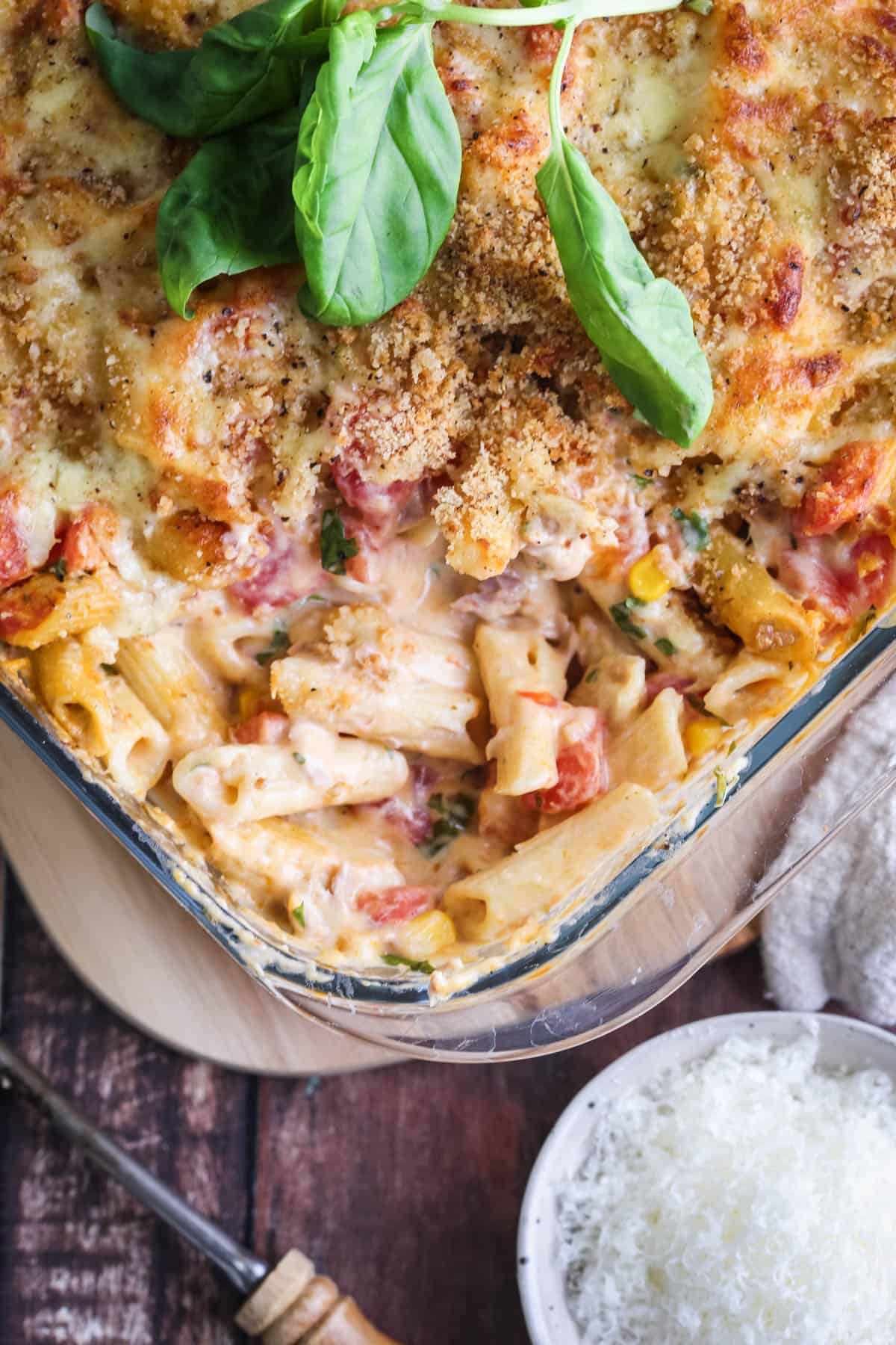 A dish of Gluten-Free Tuna Pasta Bake with a portion taken out showing creamy delicious inside.