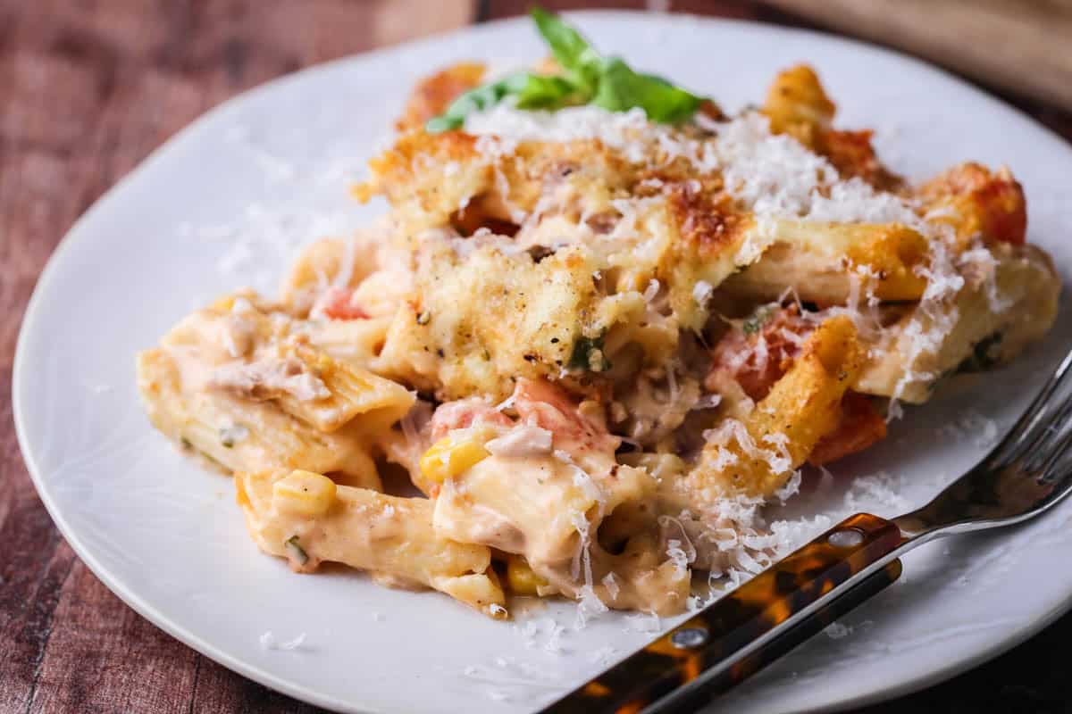 Gluten-Free Tuna Pasta Bake on a plate showing how creamy it is, with extra cheese scattered on top.