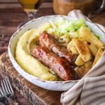 Sausages, gravy, caramelised apples and cabbage in a bowl with lashings of rich onion gravy.