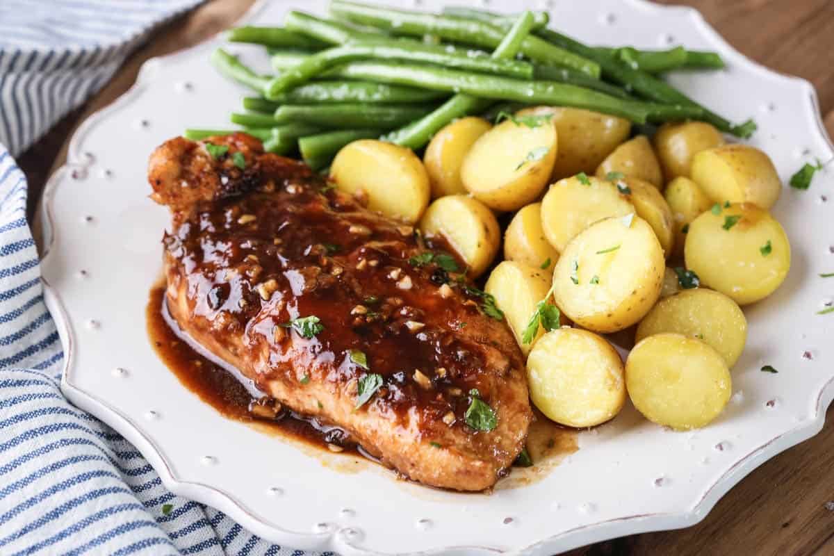 Devilled Chicken on a plate with new potatoes and green beans.
