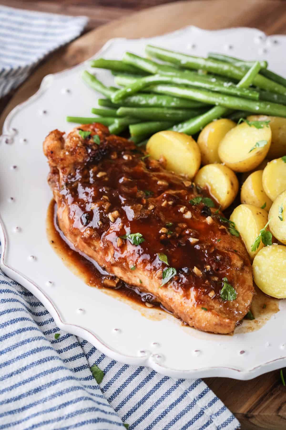 Devilled Chicken on a plate with new potatoes and green beans.