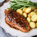Devilled Chicken on a plate with new potatoes and green beans.