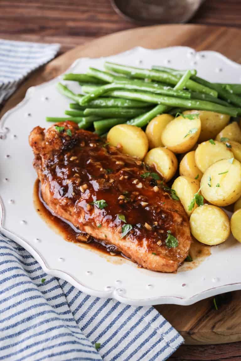 Devilled Chicken on a plate with new potatoes and green beans.