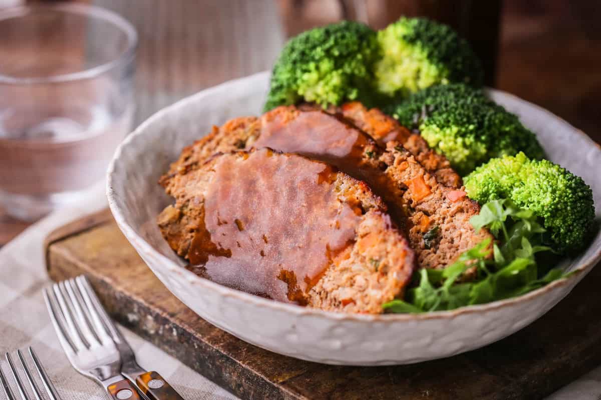 Gluten-Free Meatloaf sliced in a bowl with rich gravy.
