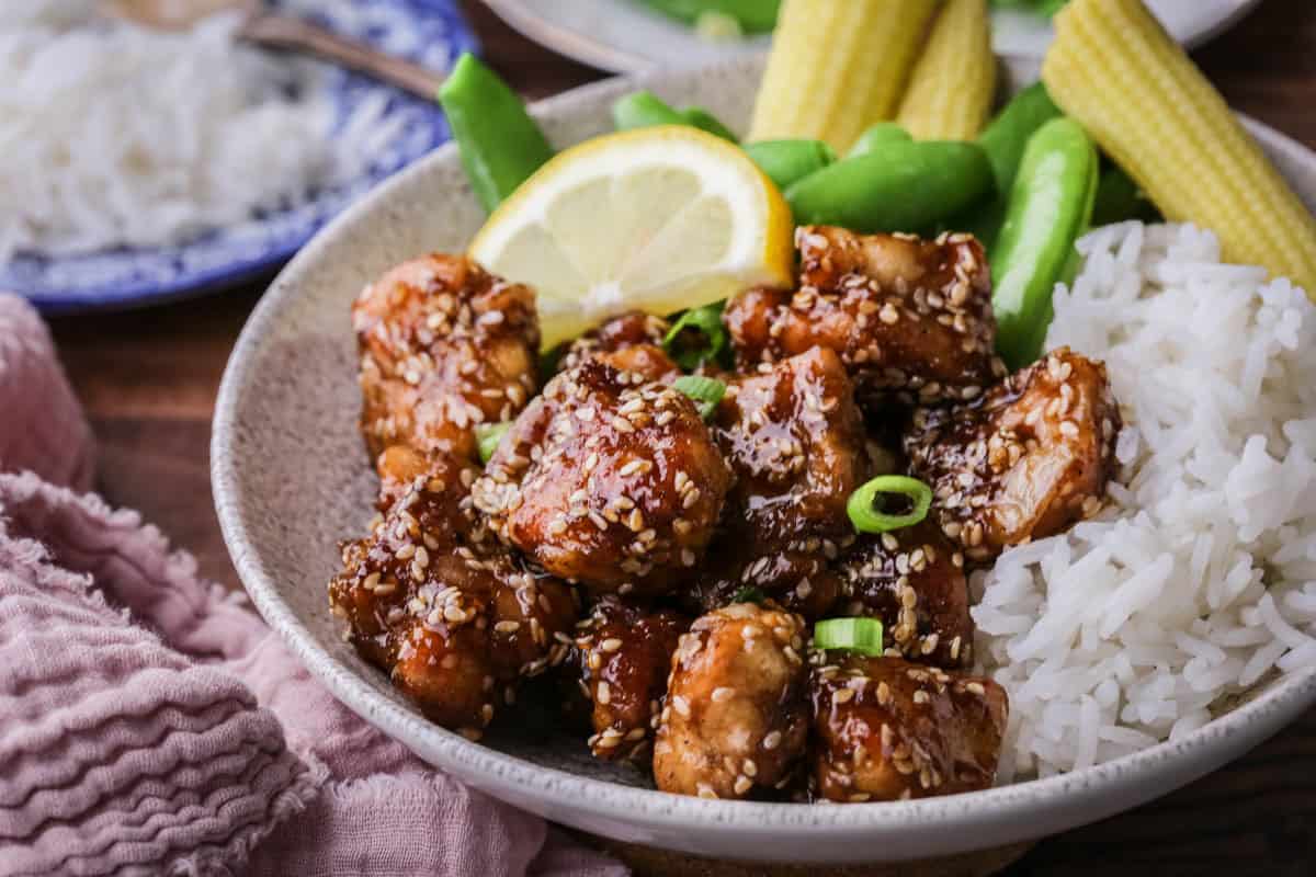 Sticky Lemon Chicken in a bowl with rice and vegetables.