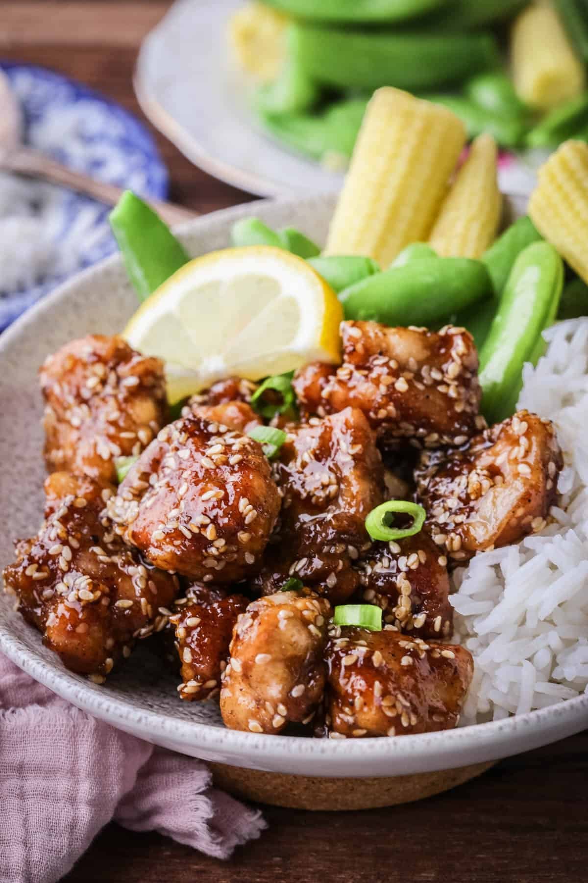 Sticky Lemon Chicken in a bowl with rice and vegetables.