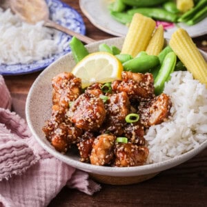 Sticky Lemon Chicken in a bowl with rice and vegetables.