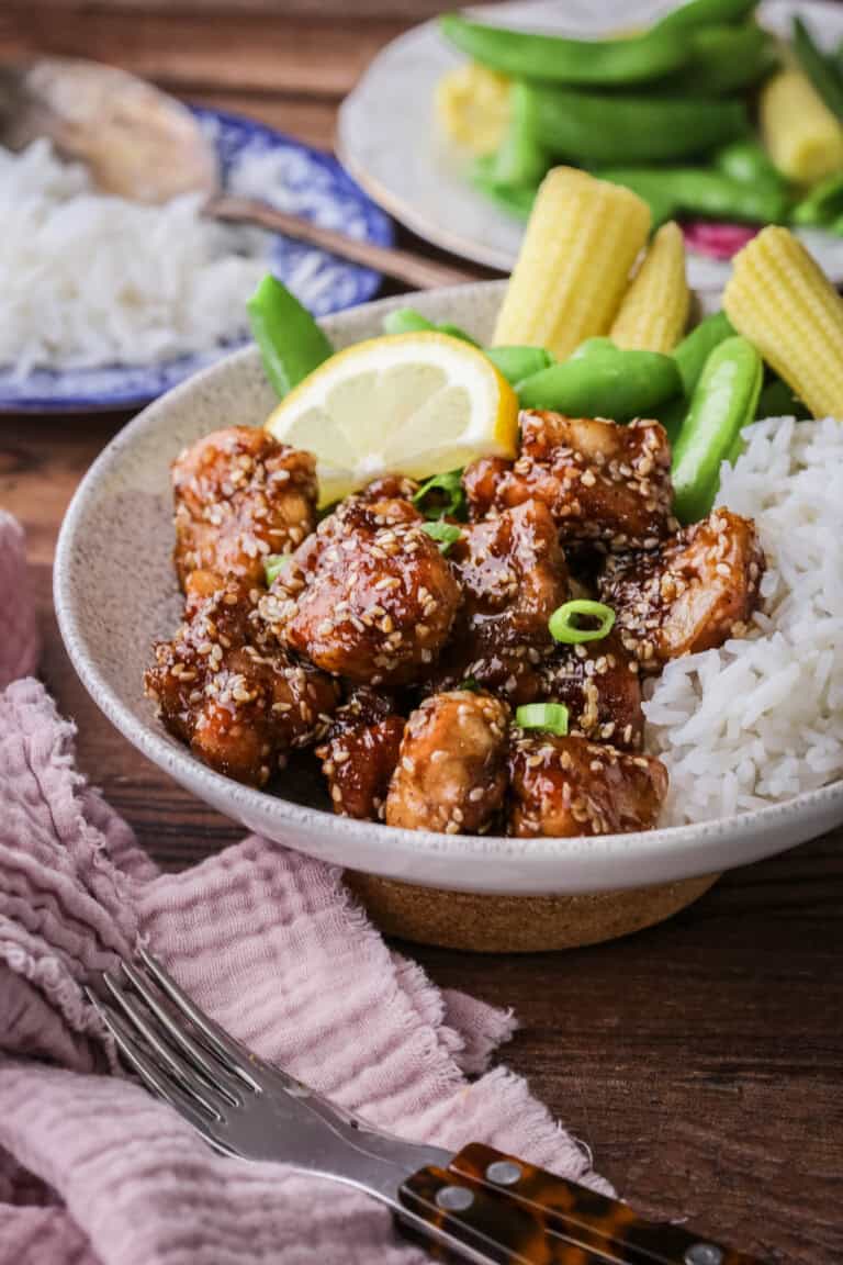 Sticky Lemon Chicken in a bowl with rice and vegetables.
