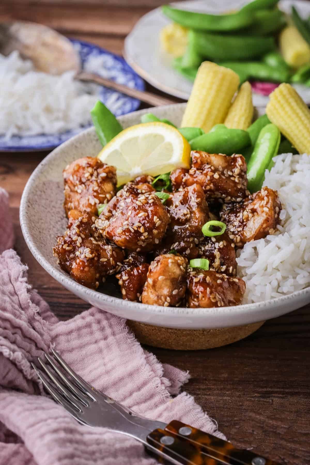 Sticky Lemon Chicken in a bowl with rice and vegetables.