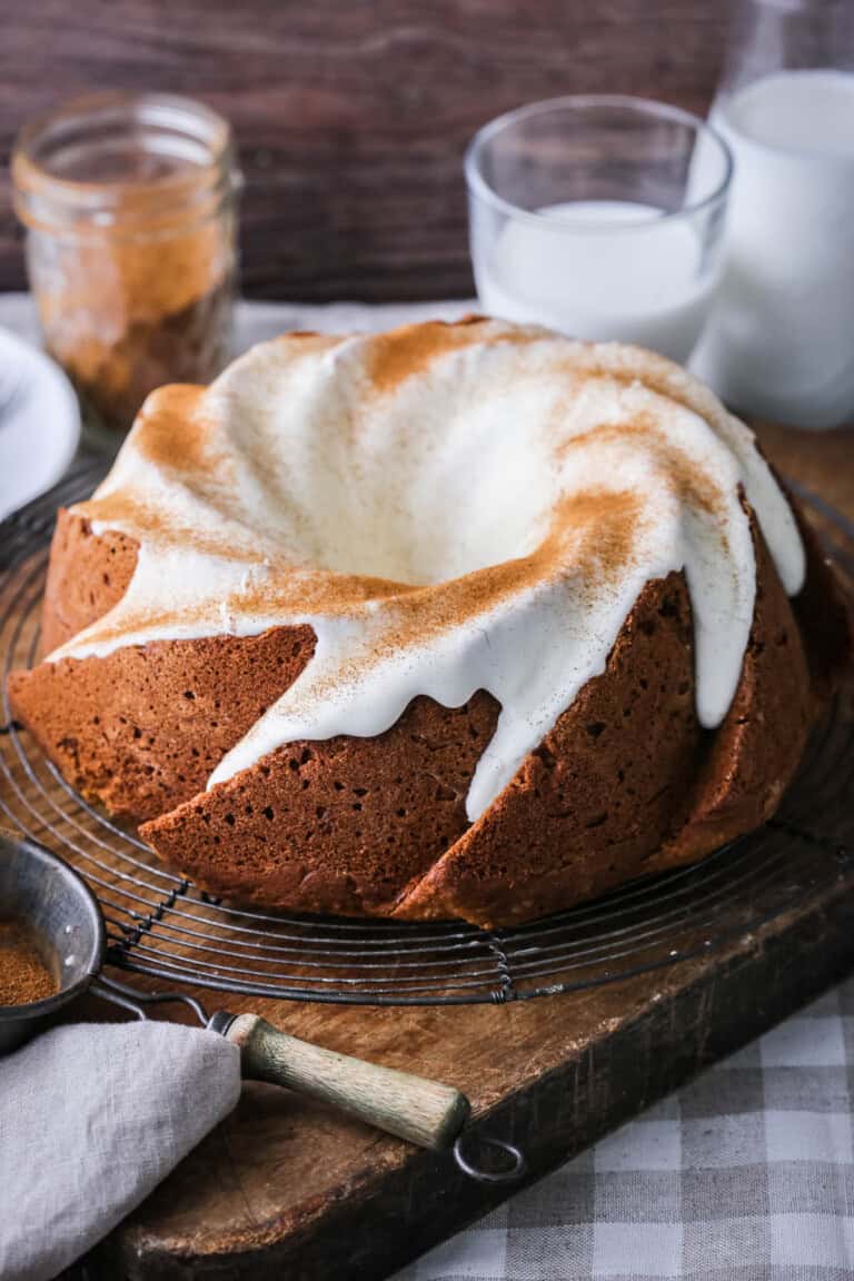Sweet Potato Cake on wire rack covered in sweet maple cream cheese icing and dusted with cinnamon.