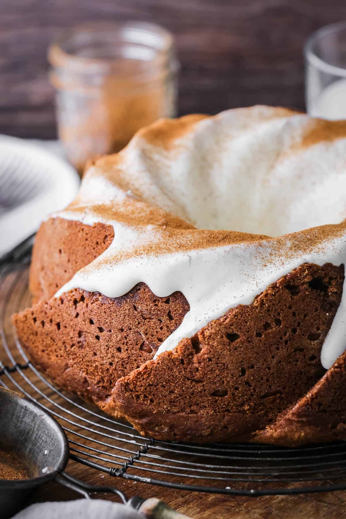 Sweet Potato Cake on wire rack covered in sweet maple cream cheese icing and dusted with cinnamon.