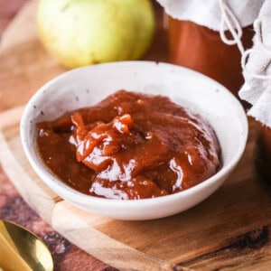 A small dish full of richly glossy thick apple butter.