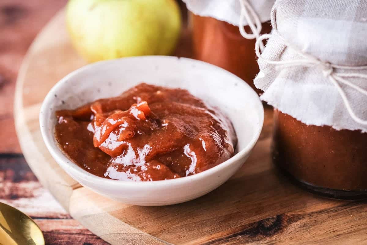A small dish full of richly glossy thick apple butter.