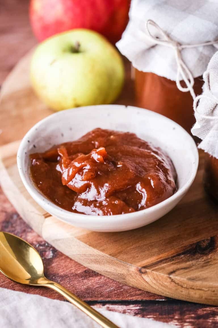 A small dish full of richly glossy thick apple butter.