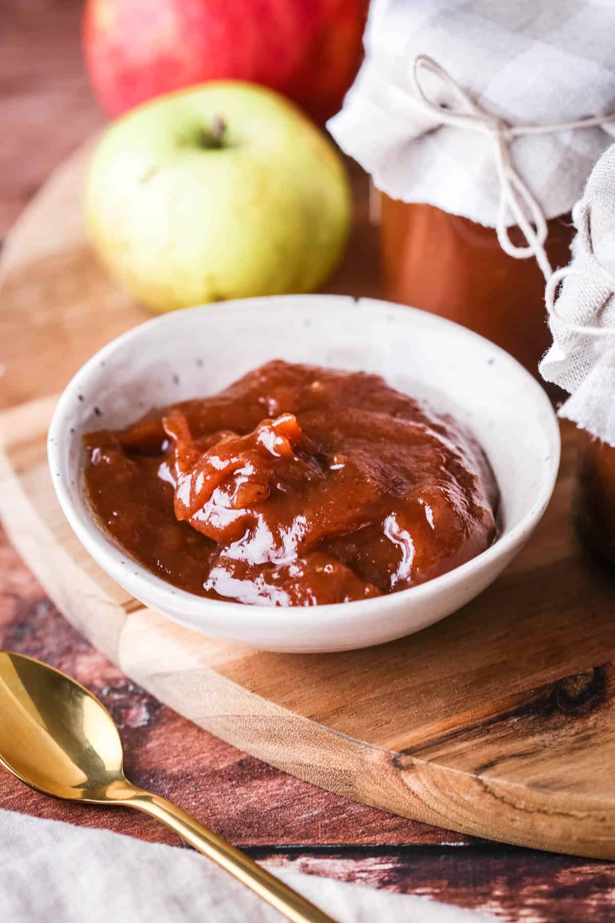 A small dish full of richly glossy thick apple butter.