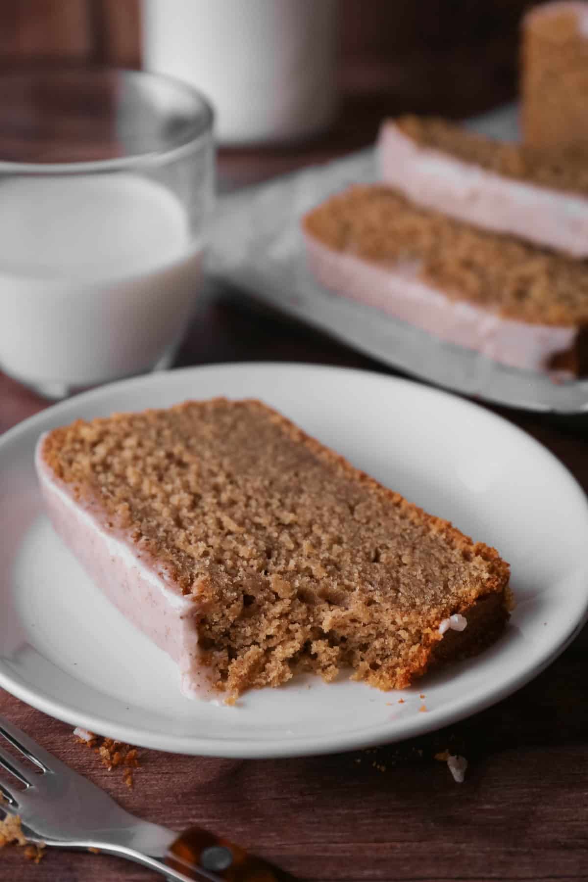 Slice of apple butter cake on a plate with forkful showing soft crumb.