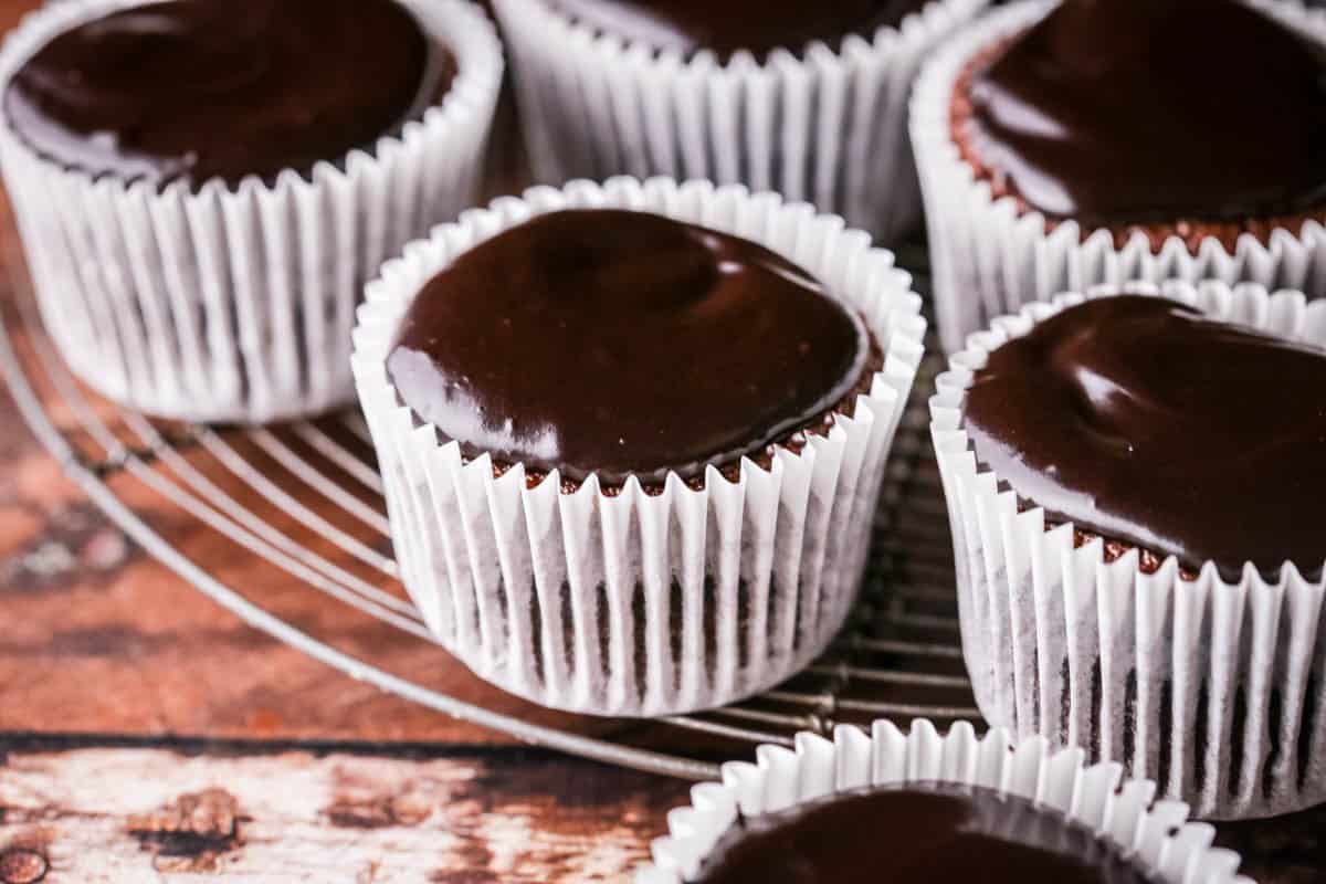 Chocolate glaze icing topped on chocolate cupcakes. Smooth and glossy.
