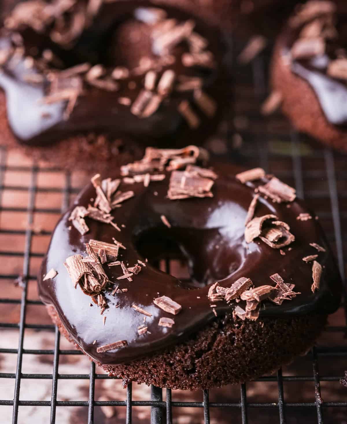 Chocolate glaze topped on chocolate doughnuts and decorated with chocolate curls.