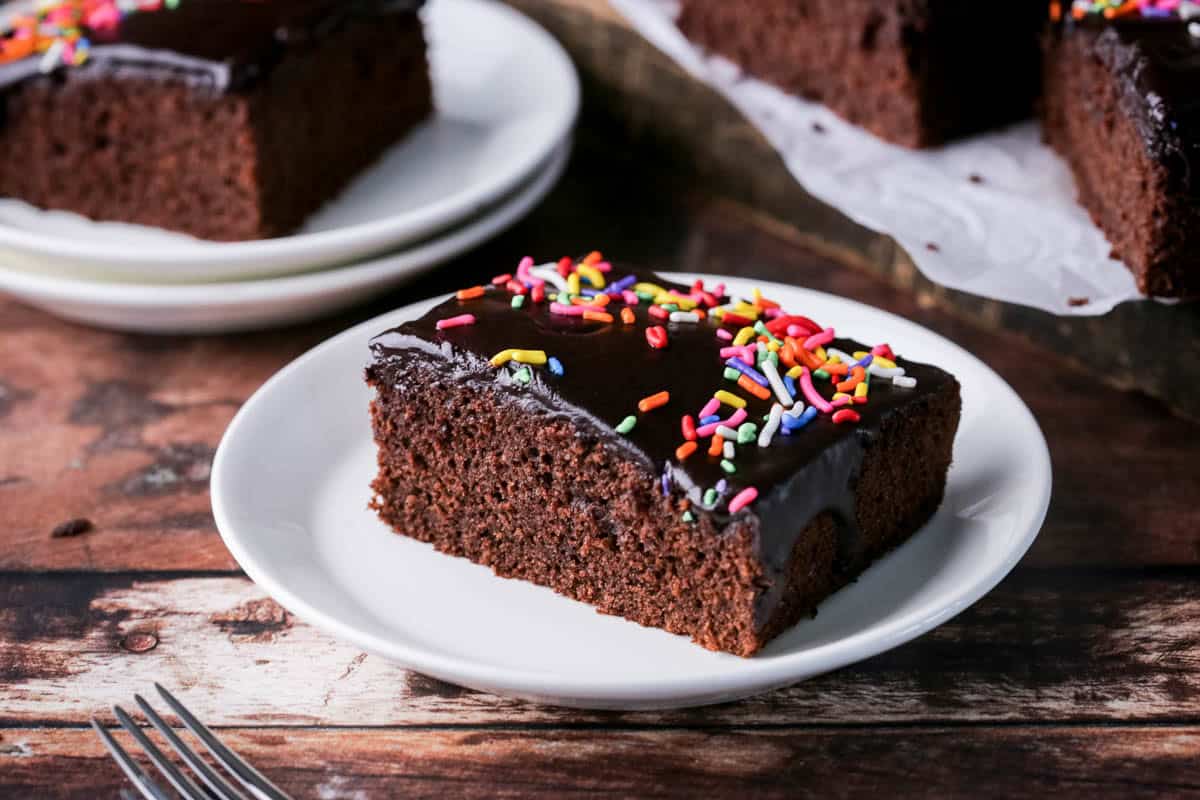 Chocolate School Cake topped with smooth chocolate icing and colourful sprinkles.