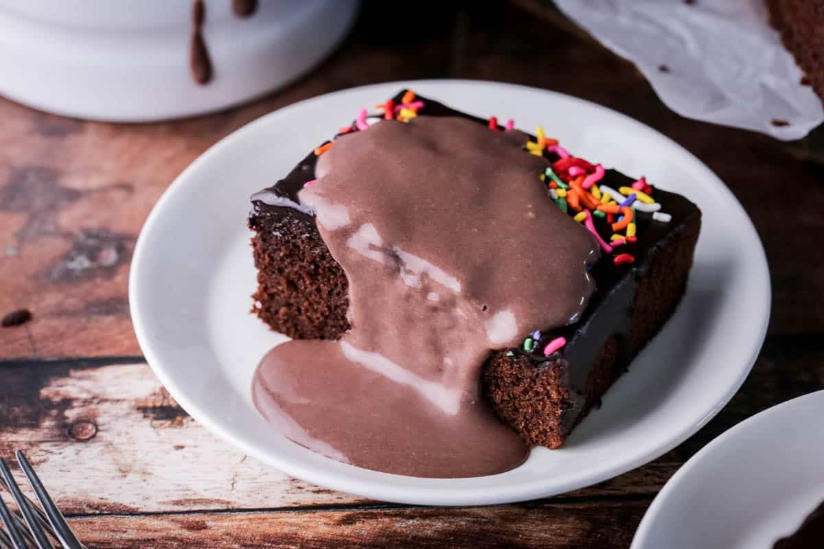 Slice of Chocolate School Cake topped with creamy chocolate custard.