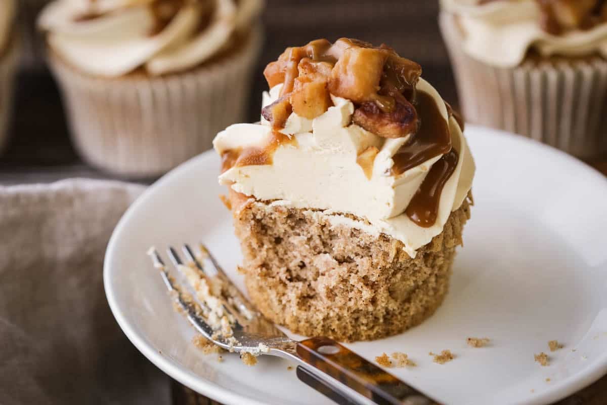 Forkful taken from Sticky Toffee Apple Cupcake showing soft and tender sponge and creamy topping of buttercream.