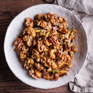 Caramelised Mixed Nuts in a bowl showing glossy walnuts, pistachios. cashews, flaked almonds and pecans.