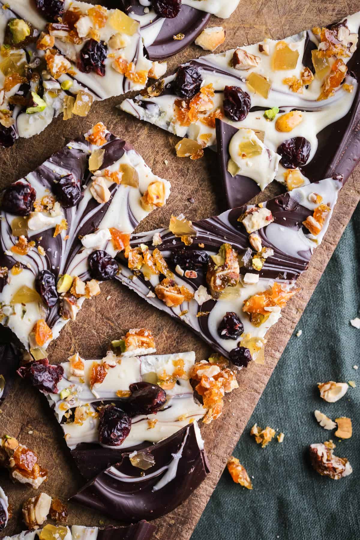 Christmas Chocolate Bark snapped into shards on a wooden board.