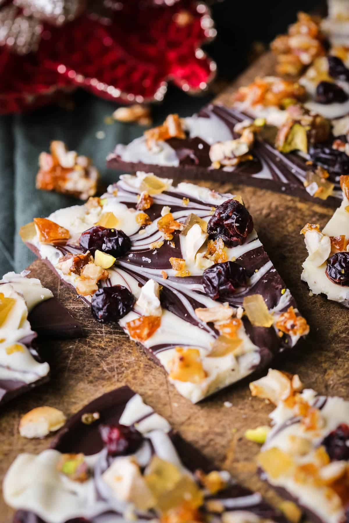 Christmas Chocolate Bark snapped into shards on a wooden board.