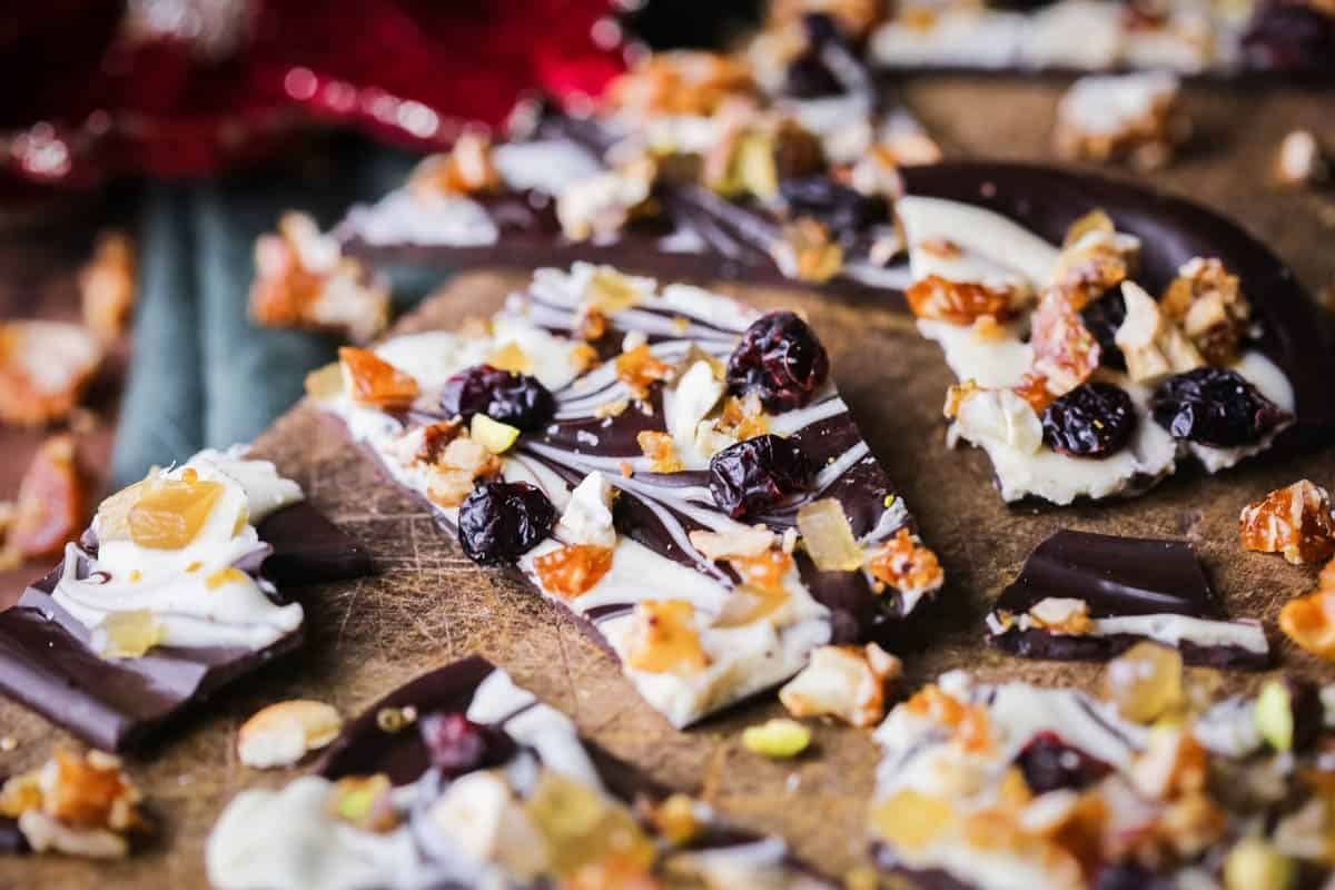 Christmas Chocolate Bark snapped into shards on a wooden board.