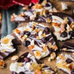 Christmas Chocolate Bark snapped into shards on a wooden board.