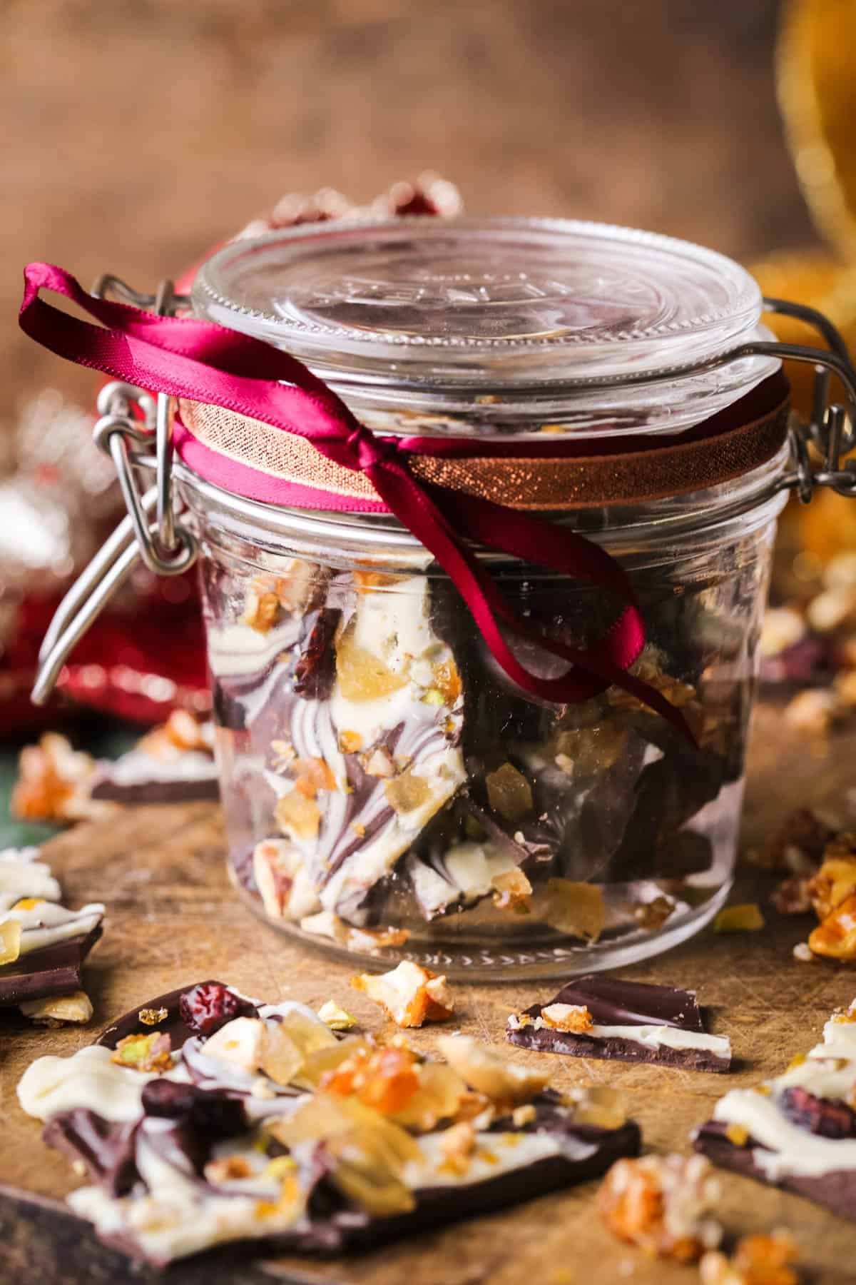 Christmas Chocolate Bark in a jar wrapped with festive ribbon.