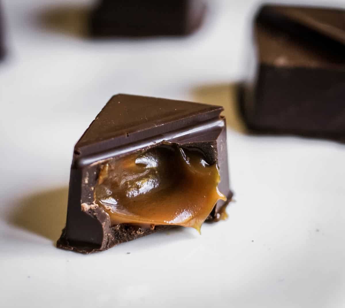 Salted caramel chocolate with caramel pouring out of centre.