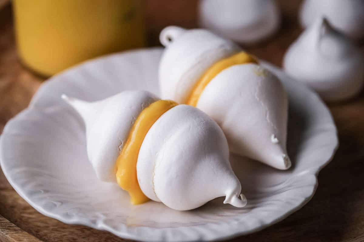 Orange curd sandwiched between two mini meringues.