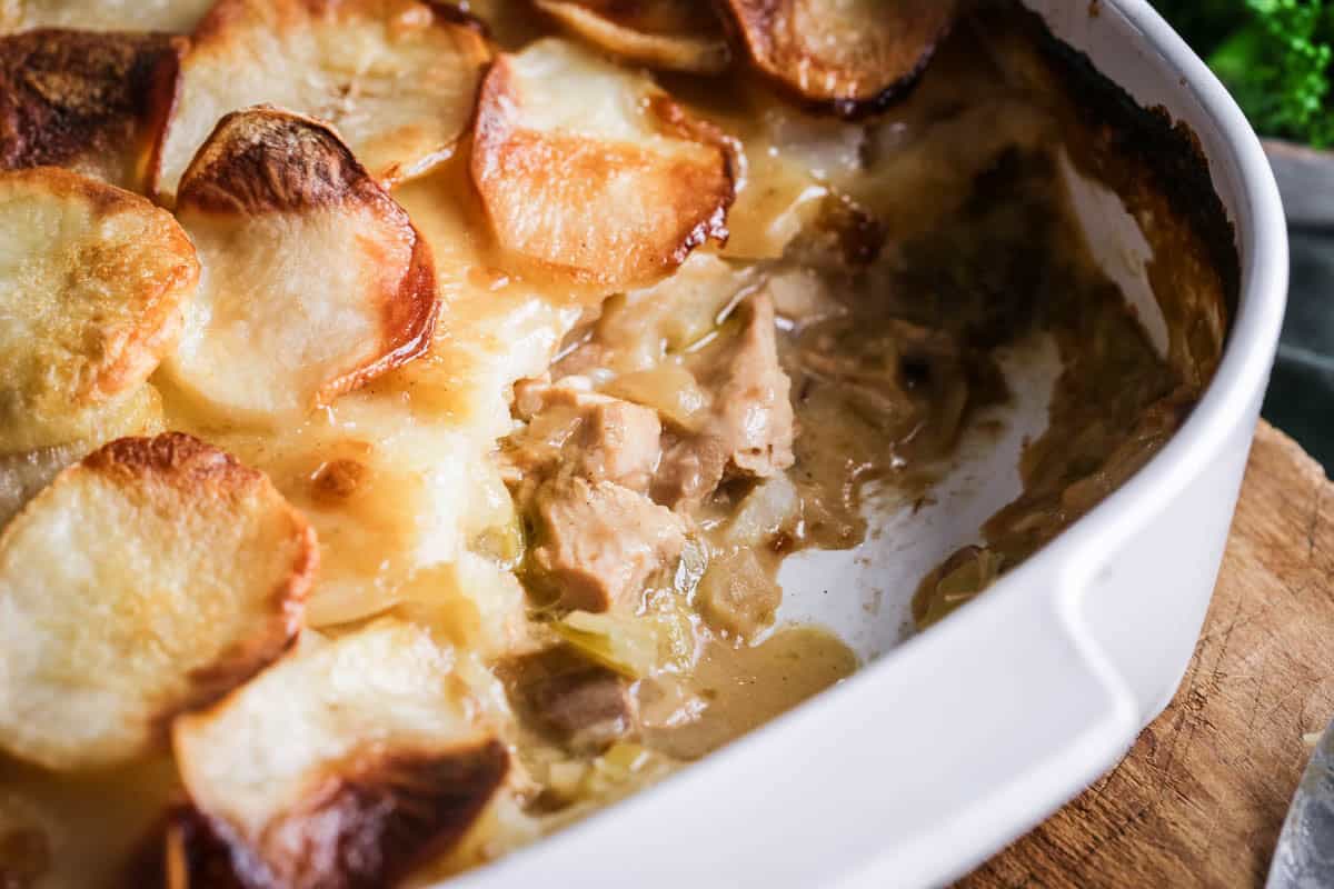 An ovenproof serving dish filled with Turkey Hotpot with creamy turkey filling covered with crisp layered potatoes.