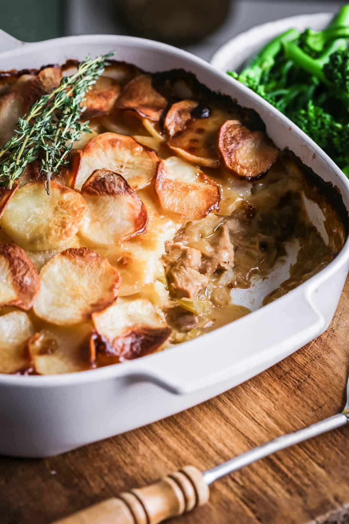 An ovenproof serving dish filled with Turkey Hotpot with creamy turkey filling covered with crisp layered potatoes.