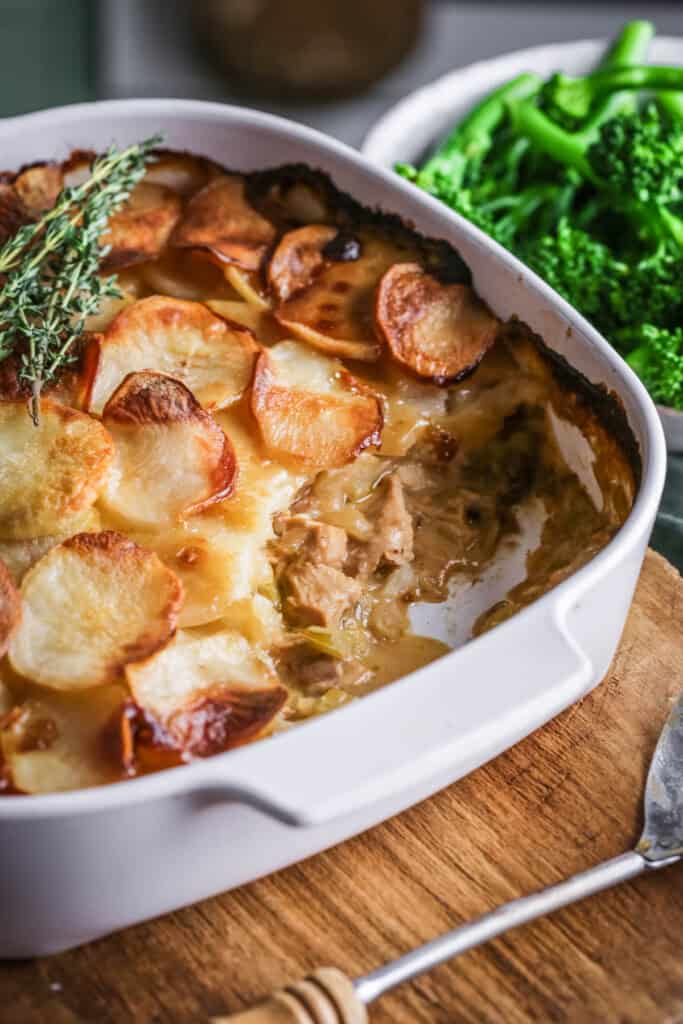 An ovenproof serving dish filled with Turkey Hotpot with creamy turkey filling covered with crisp layered potatoes.