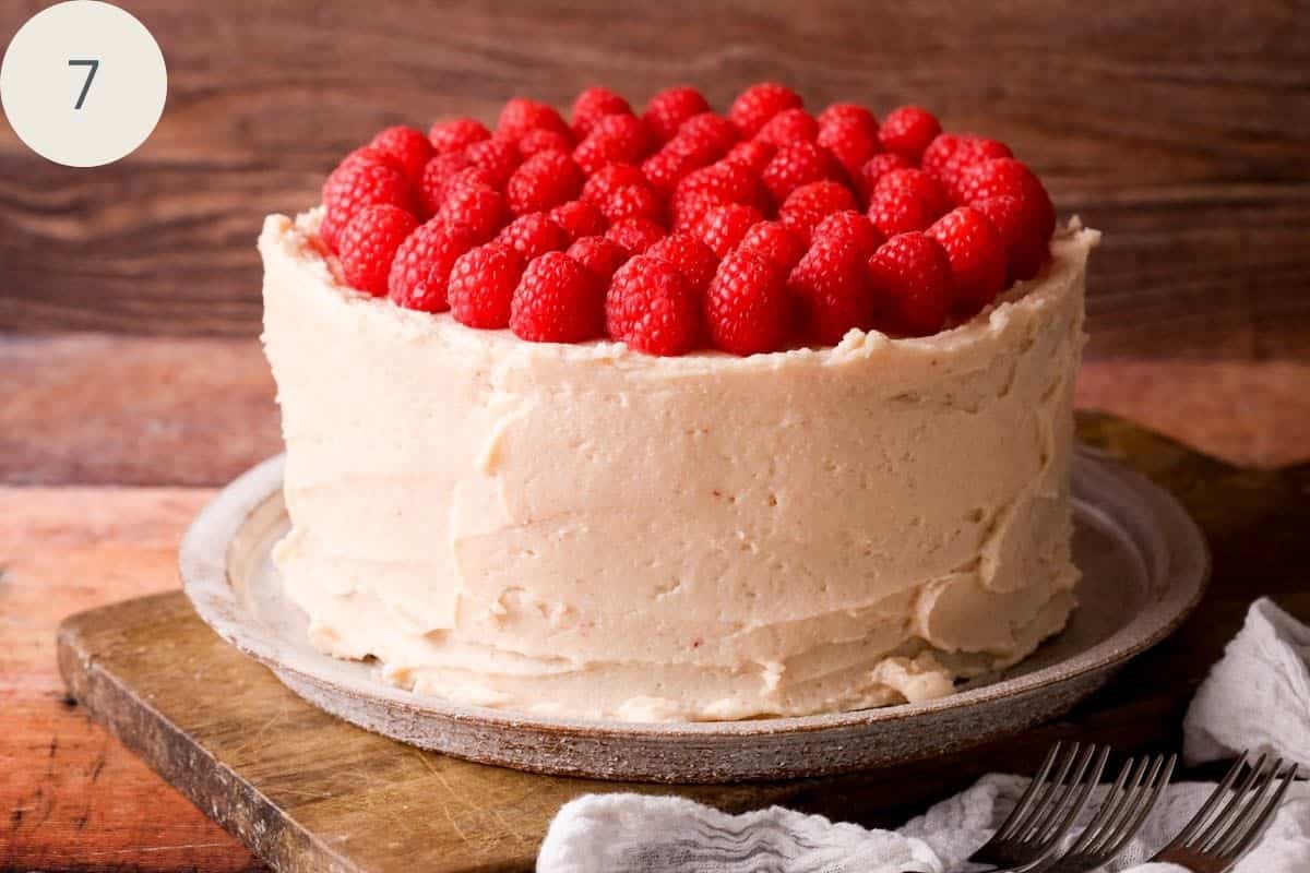 Chocolate Raspberry Cake with buttercream swirled around and topped with fresh raspberries covering the whole of the surface of the cake.
